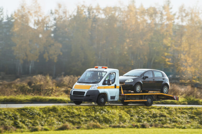 car with broken engine road being towed by truck repair shop as part roadside assistance vehicle recovery service 768x512 1